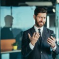 Frustrated businessman looking at phone, man got bad news while working in modern office